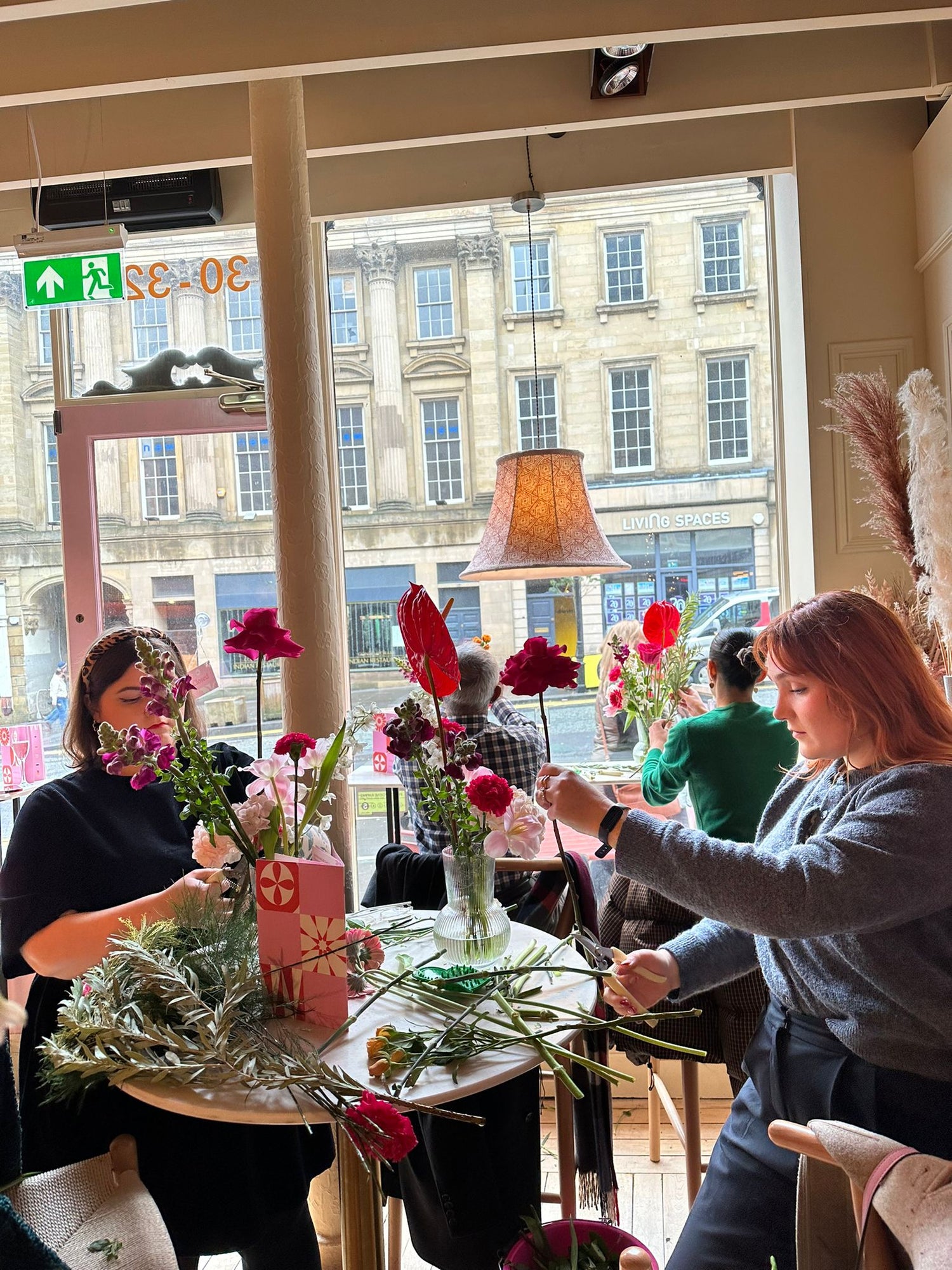 People arranging flowers at a Sunday Girl vase arrangement workshop at Cafe Mercy
